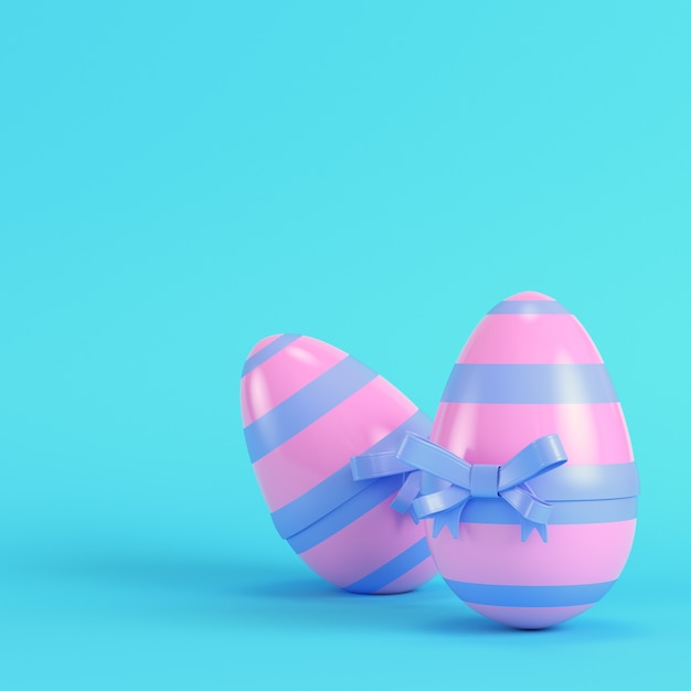 Pink easter eggs with bow on bright blue background in pastel colors. Minimalism concept