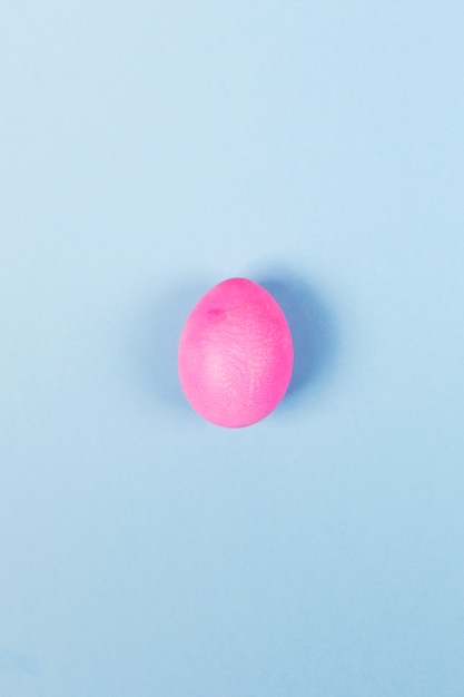 Photo pink egg on blue background. top view