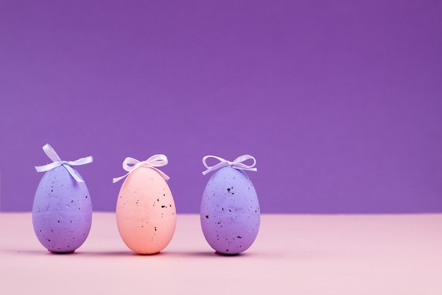 Pink egg with decor on a purple surface