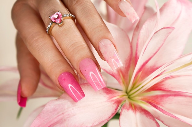 Pink elongated nail extension with fine glitter