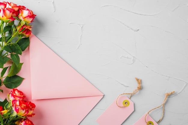 Pink envelope with flowers, top view. Romantic letter