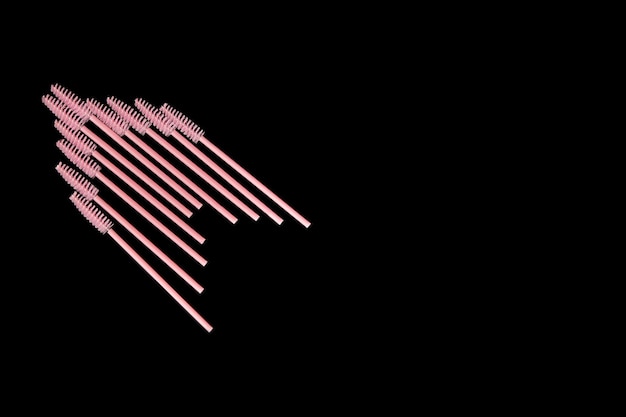 Pink eyelash brushes on a black background Cosmetic accessories for eyelash extensions