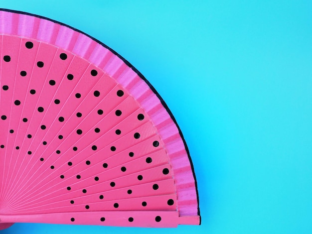 A pink fan with black dots closeup