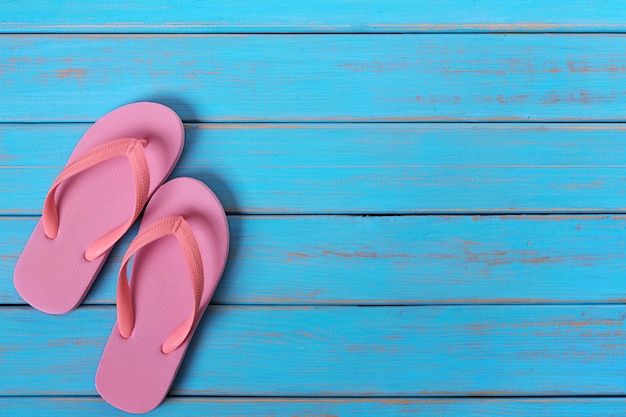 Pink flip flop sandals old summer beach wood background painted