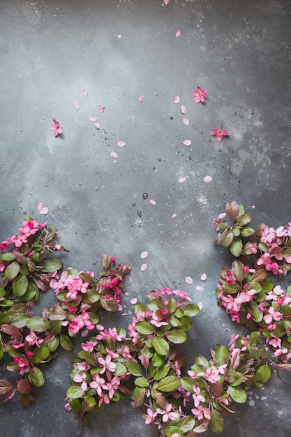 Pink flowers of blossoming fruit tree on vintage table.