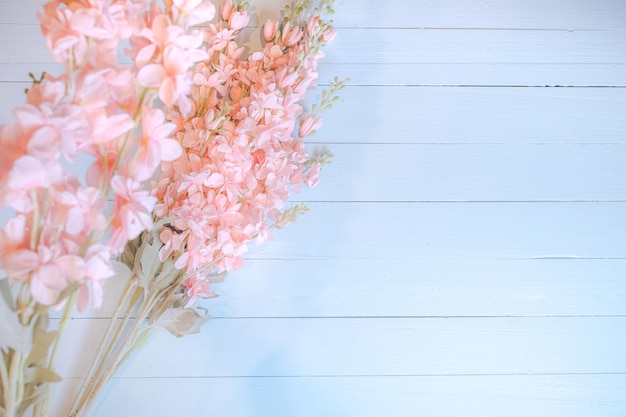 Pink flowers on blue wooden background