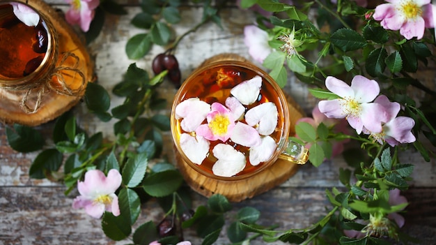 Pink flowers and leaves of rose hips tea