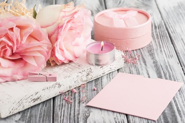 Pink gift box, roses, lit candle