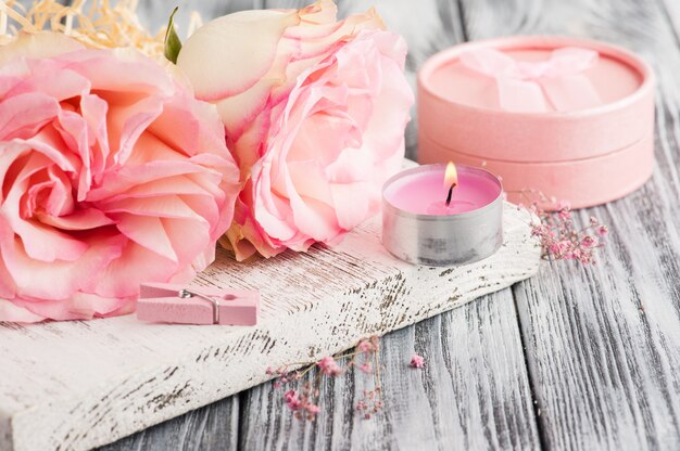 Pink gift box, roses, lit candle