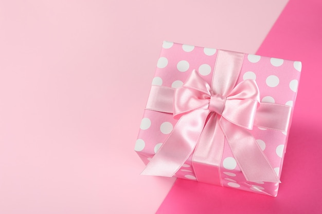 Pink gift box on two tone background