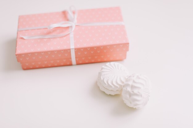 pink gift box with bow on white surface