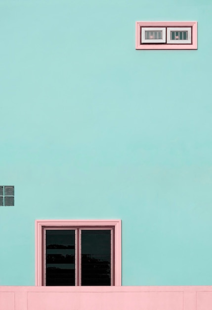 Pink glass windows on blue house wall with concrete fence in pastel colors tone style