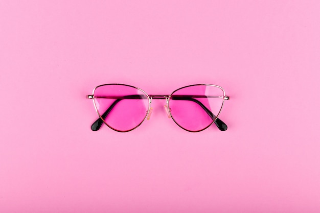 Pink glasses on a pink background.