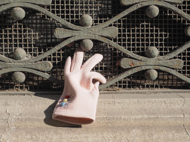 Pink glove on window grate