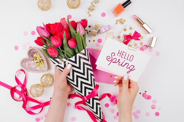 Pink and Gold Styled Desk with Florals. Female hands hold card