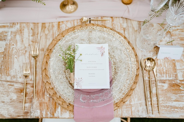 A pink and gold wedding reception table with a menu for the bride and groom.