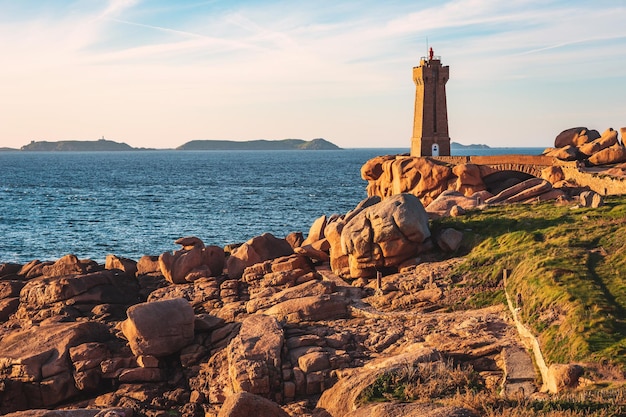 Pink Granite Coast in Brittany near Ploumanach, France.Ploumanach Mean Ruz lighthouse red sunset in pink granite coast, Perros Guirec, Brittany