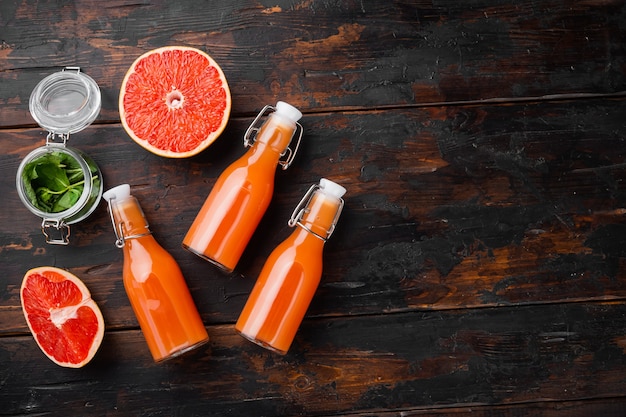 Pink grapefruit juice set, on old dark  wooden table background, top view flat lay, with copy space for text