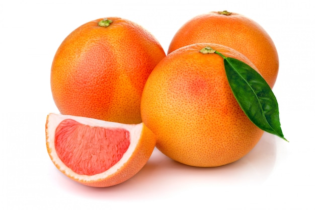 Pink grapefruits with green leaves isolated on white