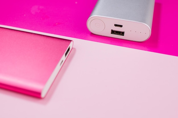 Pink and gray power bank on background