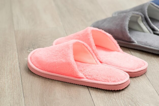 바닥에 있는 분홍색과 회색 슬리퍼 리놀륨 바닥에 있는 가정용 신발