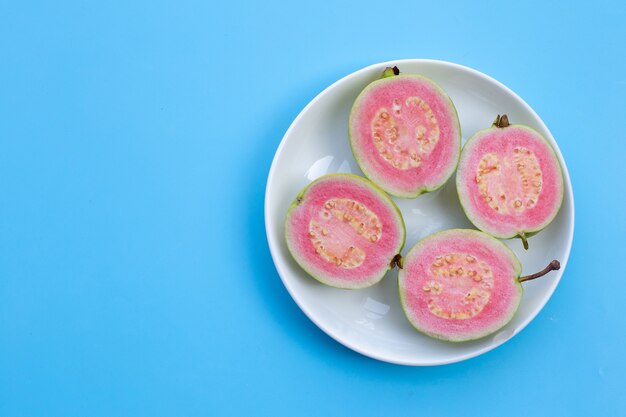 Pink guava on plate on blue