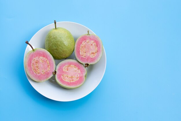 Pink guava on plate on blue
