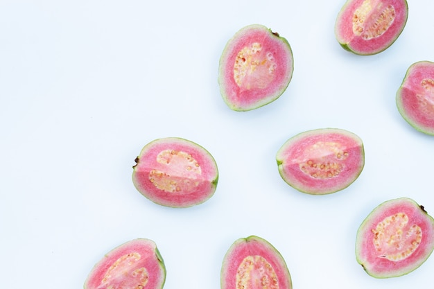 Pink guavas on white surface