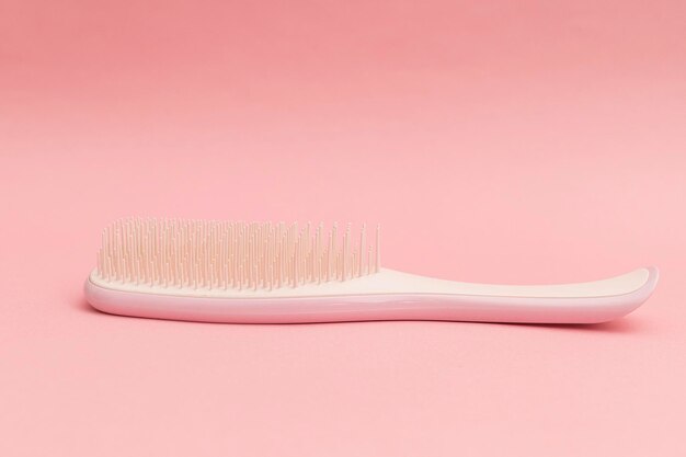 Pink hairbrush on pink background monochrome