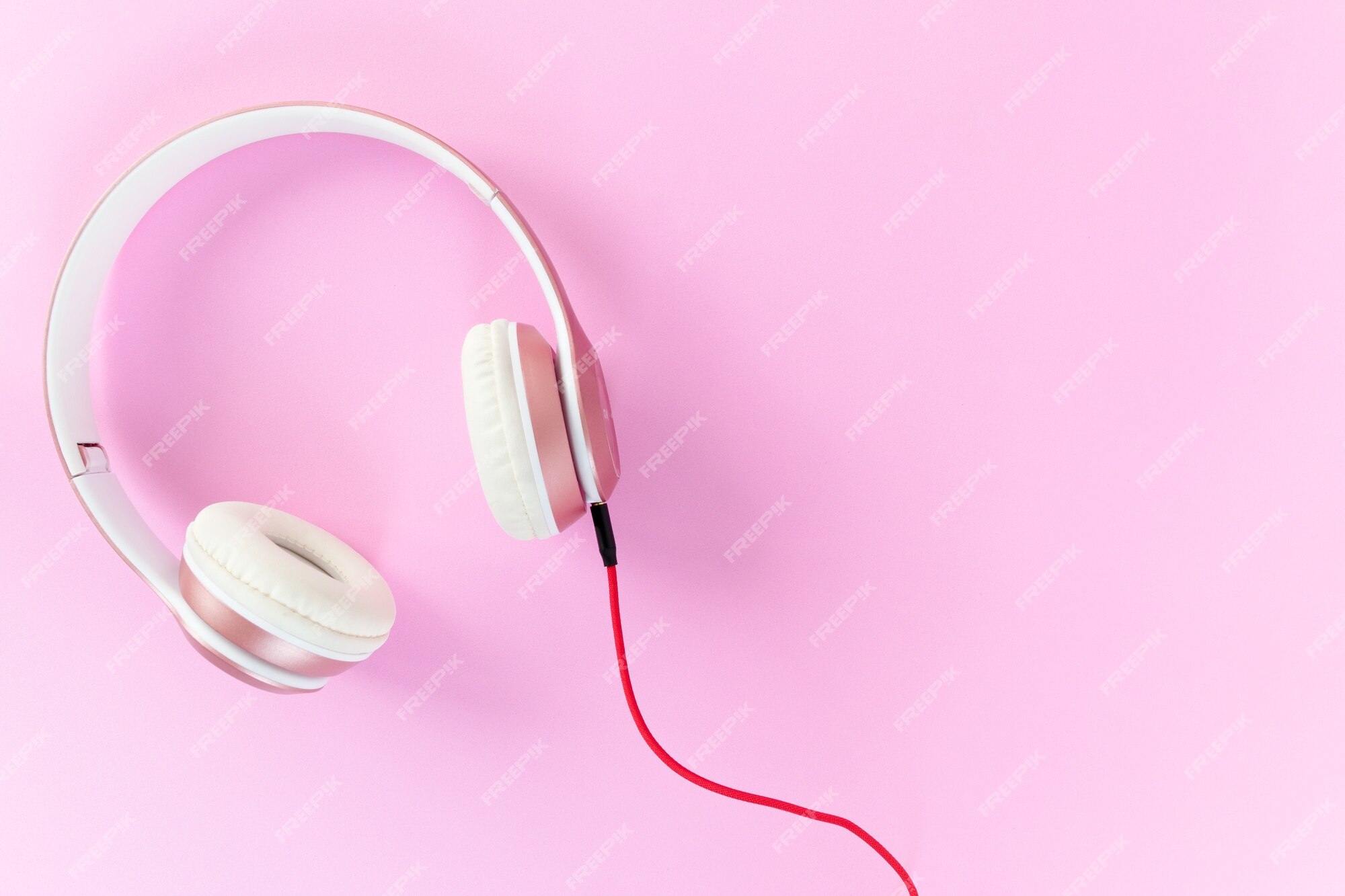 Premium Photo | Pink headphone and red cable on pastel color pink background.  music concept.