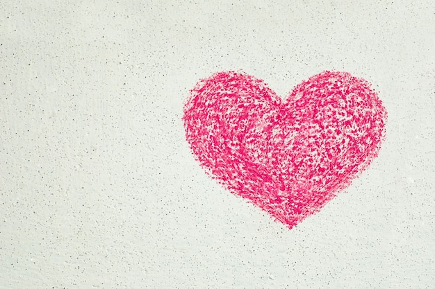 Cuore rosa disegnato con il gesso sul muro bianco, copia spazio