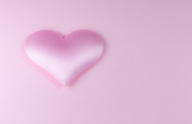 Фото Розовое сердце на розовом фоне. концепция дня святого валентина. любовное и романтическое фото. открытка к празднику. красивые теплые обои с любовью. мягкий фокус. скопируйте пространство.