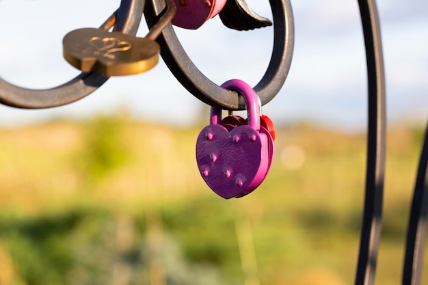 Pink heart shaped lock hangs from bridge chain wedding custom is symbol of eternal love