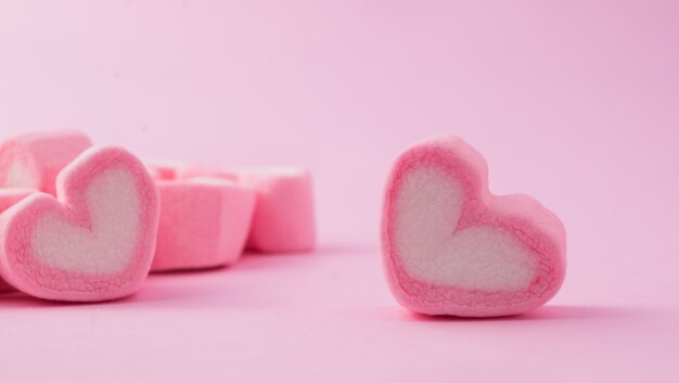 Pink heart-shaped marshmallow in with pink background  