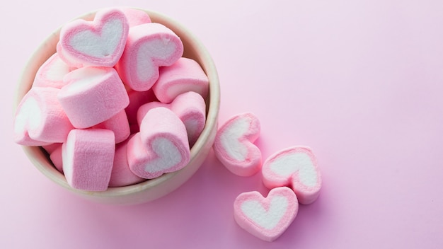 Pink heart-shaped marshmallows in with pink background