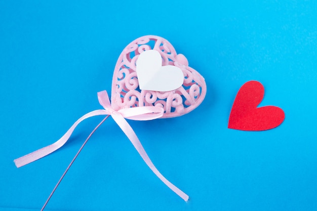 Photo pink heart with little red hearts on blue background