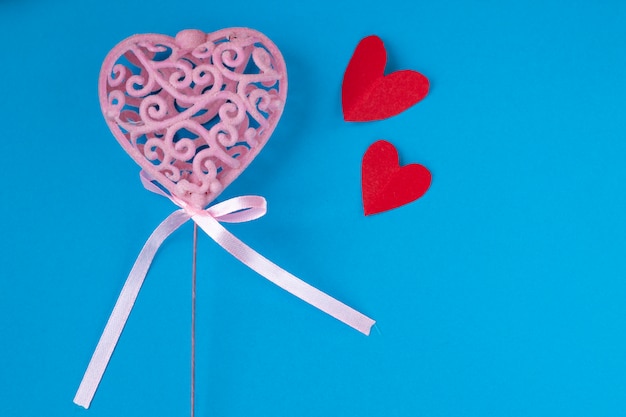 Photo pink heart with little red hearts on blue background