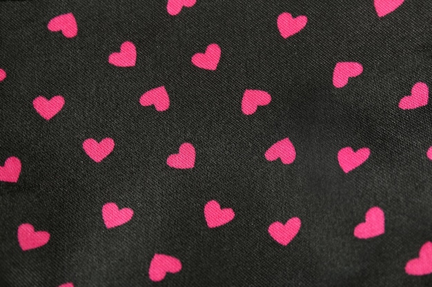 Pink hearts pattern on black background