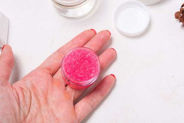 Pink homemade pil balm scrub in woman hand