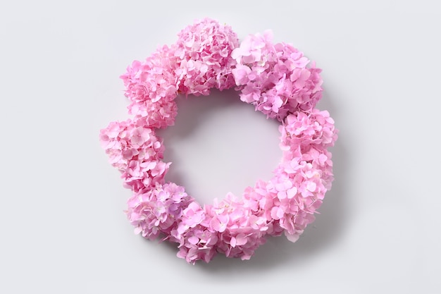 Pink hydrangea flowers as wreath on grey