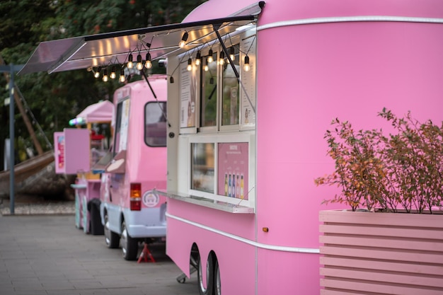 pink ice cream vans on street in city mobile fair trade with food trucks