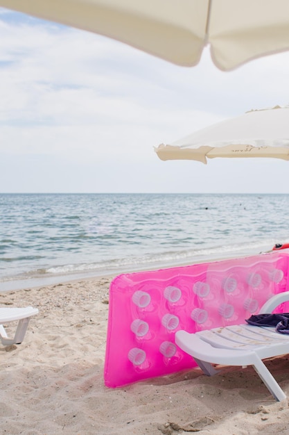 Pink inflatable mattress on the seashore