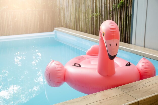 Pink inflatable ring flamingo plastic in the swimming pool blue water