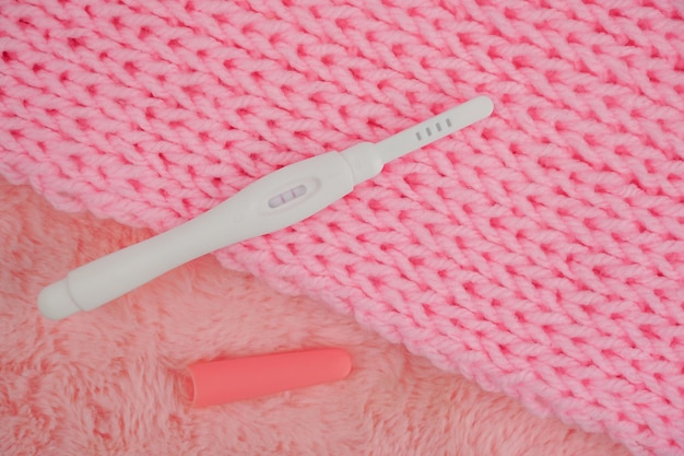 A pink knitted blanket with a white electric device on it.