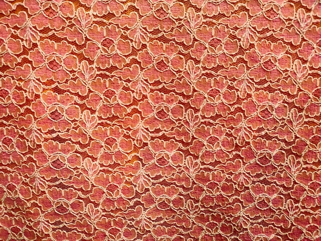 A pink lace fabric with a floral pattern.
