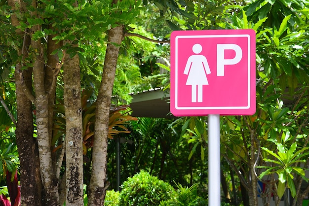 Segno di parcheggio per signore rosa sullo sfondo della natura