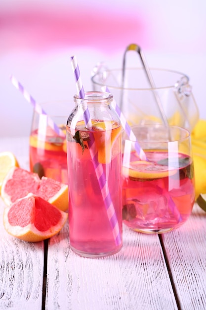 Pink lemonade on table on bright background closeup