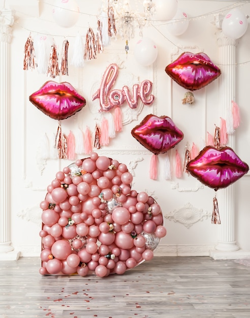 Pink and lips balloons on white wall