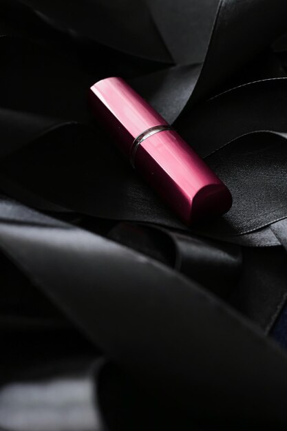 Pink lipstick on black silk background luxury makeup and beauty cosmetic