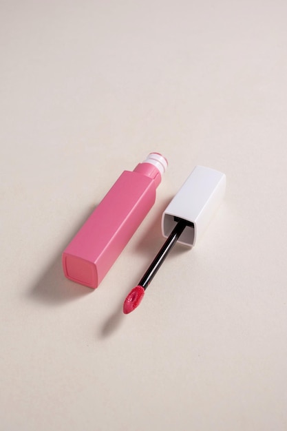 Розовая жидкая помада и кисть-аппликатор с открытой трубкой Макияж косметический продукт Нейтральный теплый фон